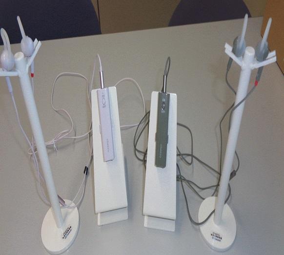 机の上に置かれた白い軟骨伝導イヤホン2台の写真