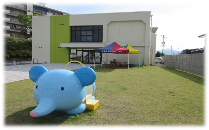 青いゾウの遊具が置かれたくまの・こども夢プラザの中庭の写真