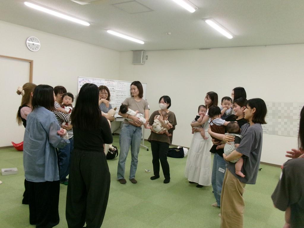 女性たちが赤ちゃんをだっこしながら笑い合っている写真