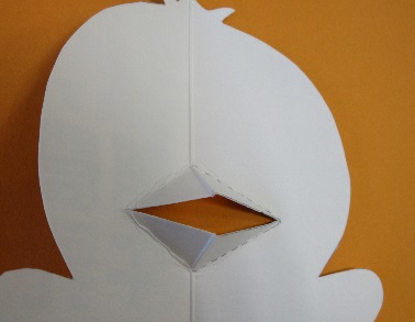 キャラクターの形に切られた紙に穴が開けられている写真