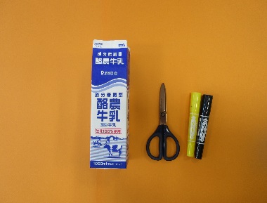 牛乳パック、ハサミ、マジックが並んで置かれている写真
