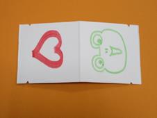 切れ込みの入った牛乳パックの内側にハートマークとカエルが描かれている写真