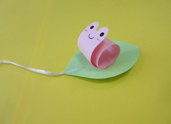 紙で出来た葉っぱに乗っている紙製のかたつむりの写真