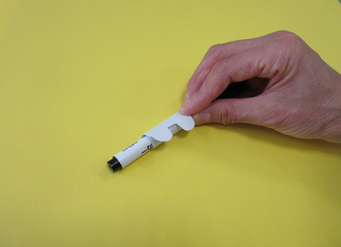 先端が2つの山になっている紙をペンに巻き付けている写真