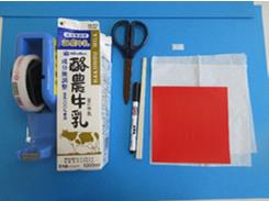 セロテープ、牛乳パック、ハサミ、ペン、折り紙が並んで置かれている写真