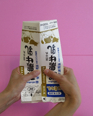 牛乳パックに力を加えて変形させている写真