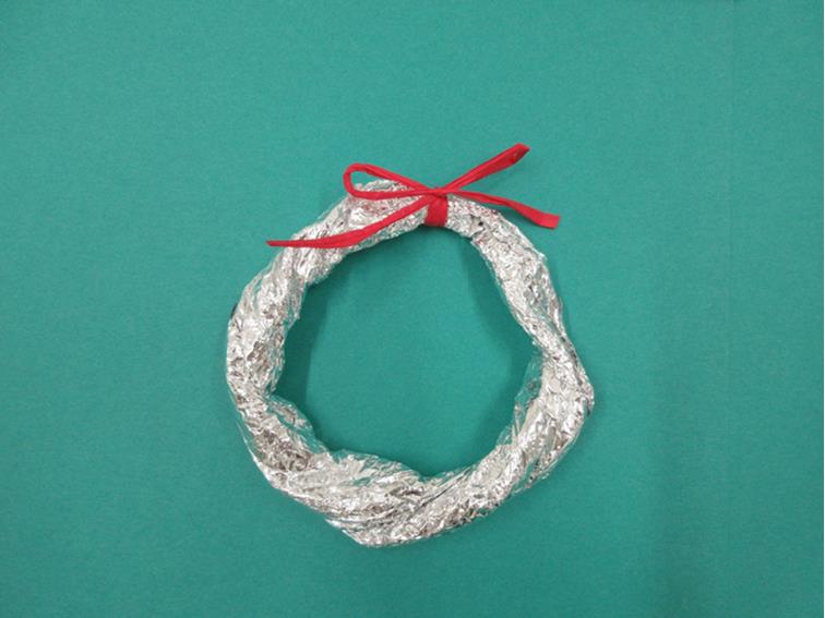 輪っか型のアルミホイルに赤いリボンが巻かれている写真