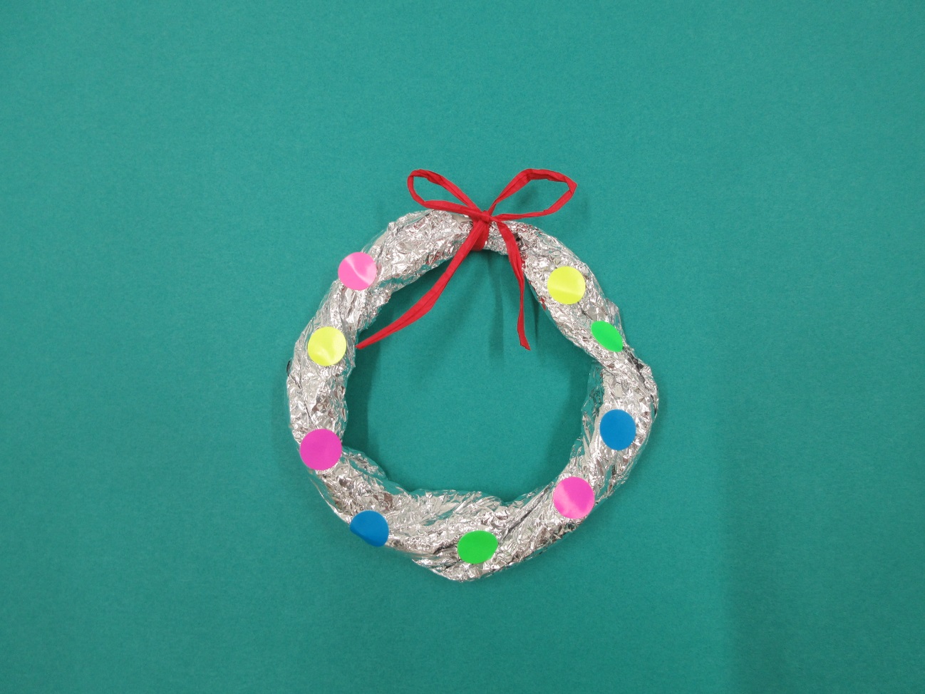 輪っか型のアルミホイルに赤いリボンやシールが付けられている写真