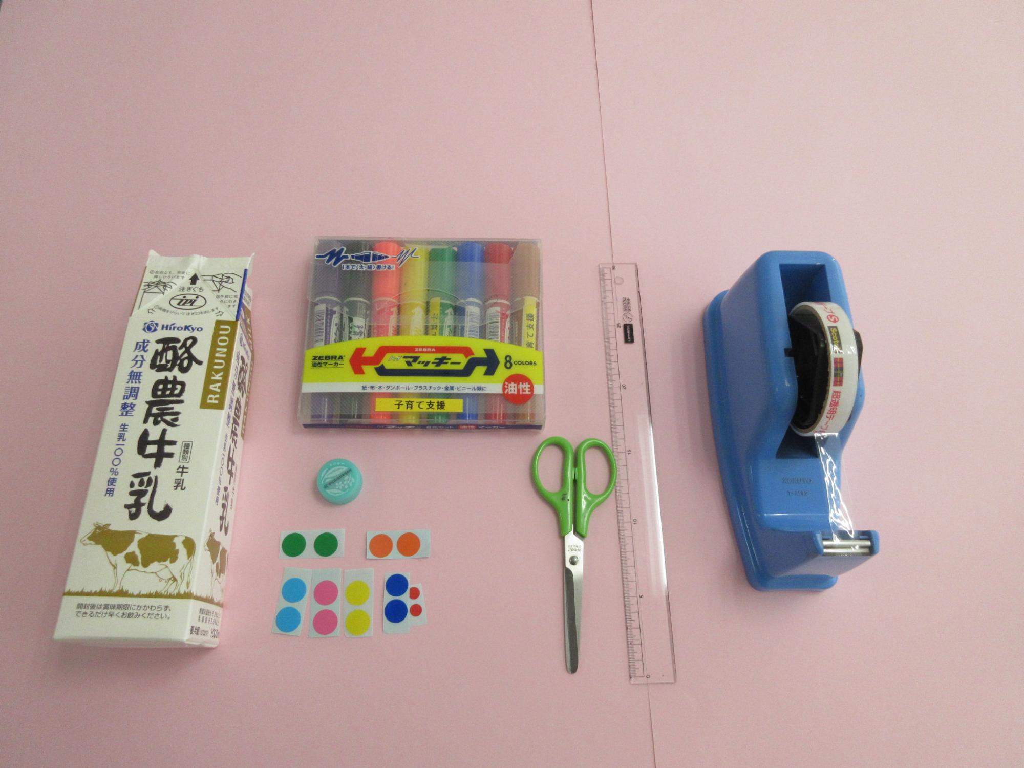 牛乳パック、マジック、シール、ハサミ、定規、セロテープが並んで置かれている写真