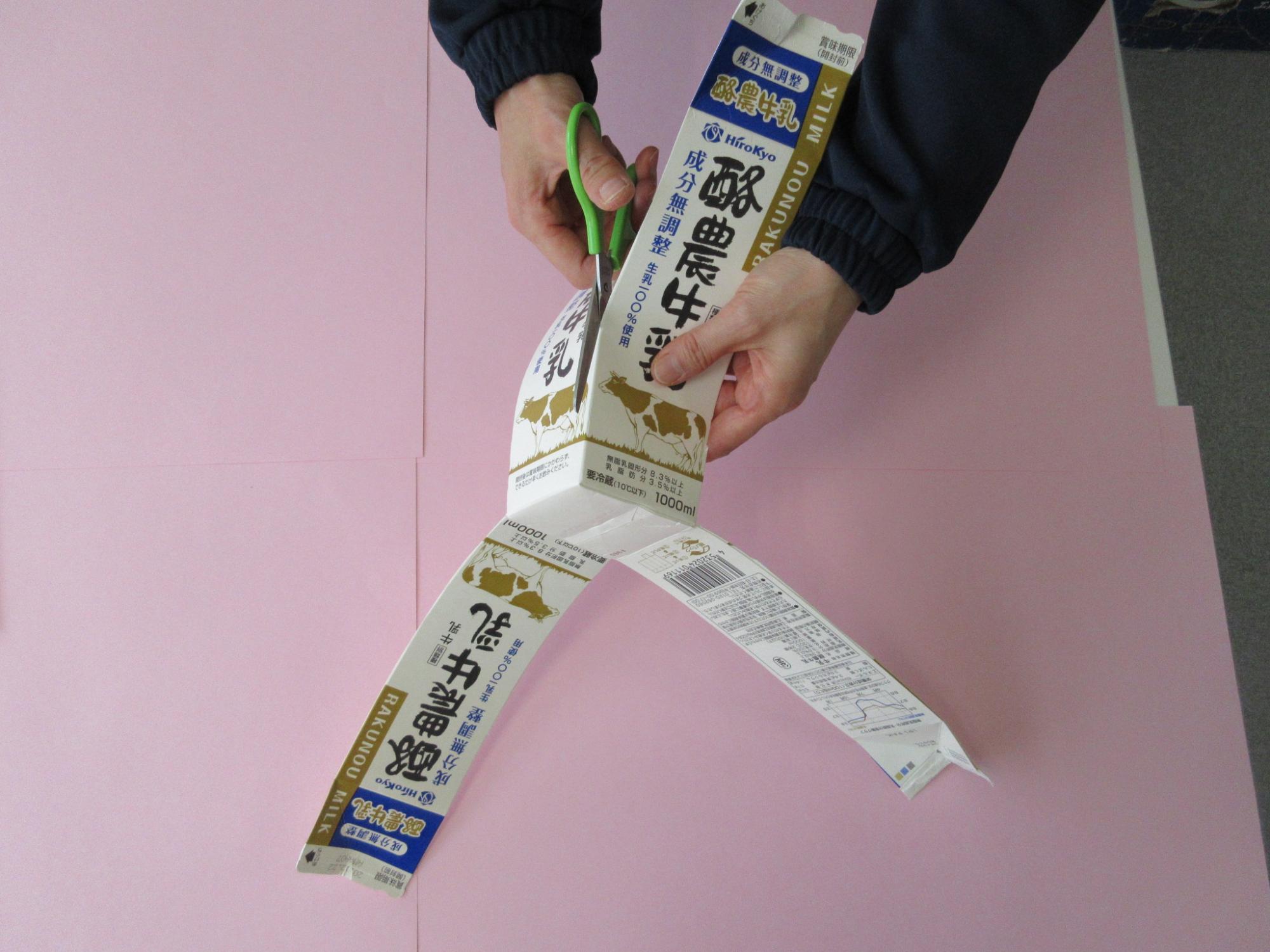 牛乳パックの四隅にハサミを入れている写真
