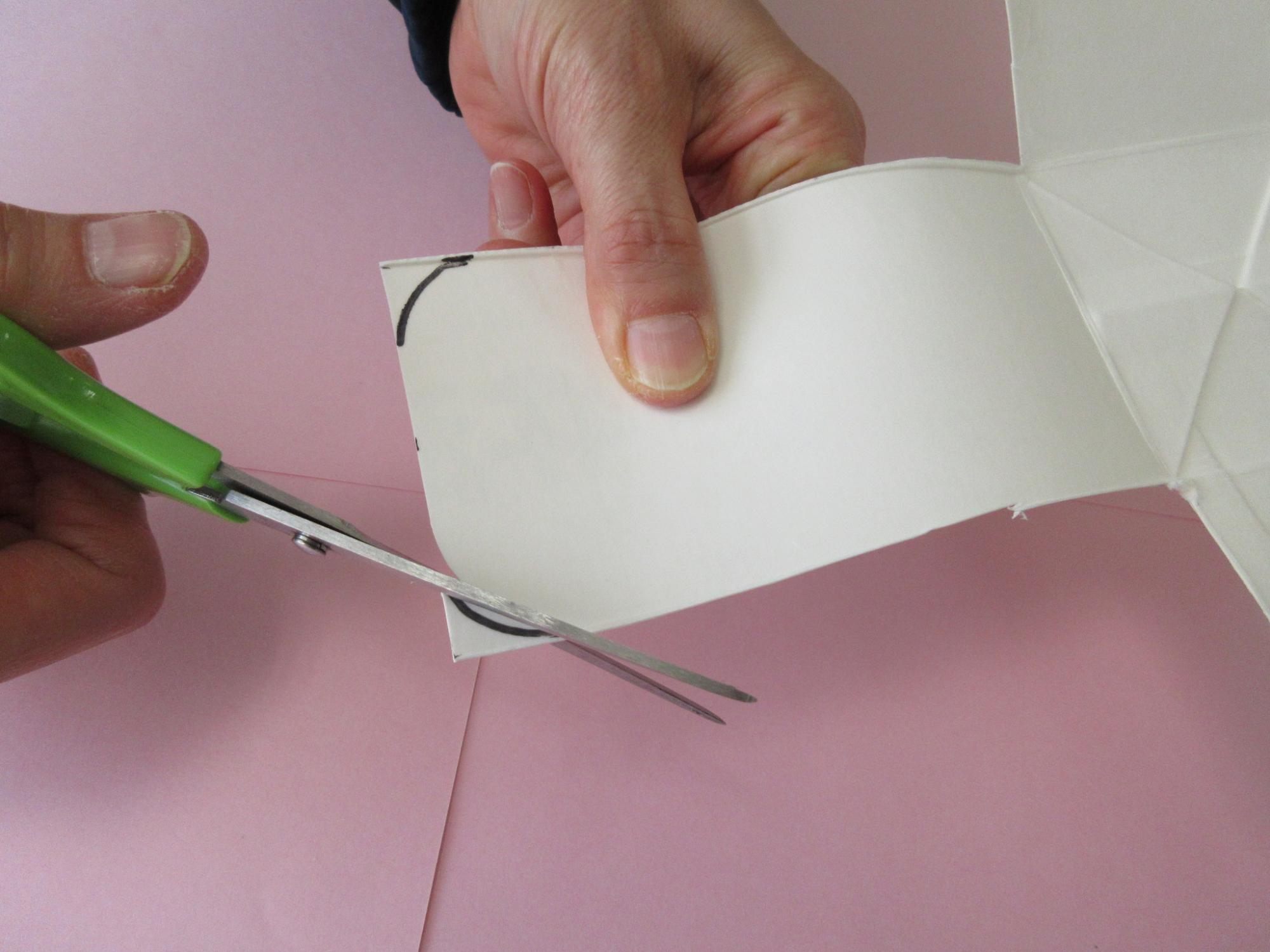 牛乳パックの内側に描かれた曲線に合わせてハサミを入れている写真