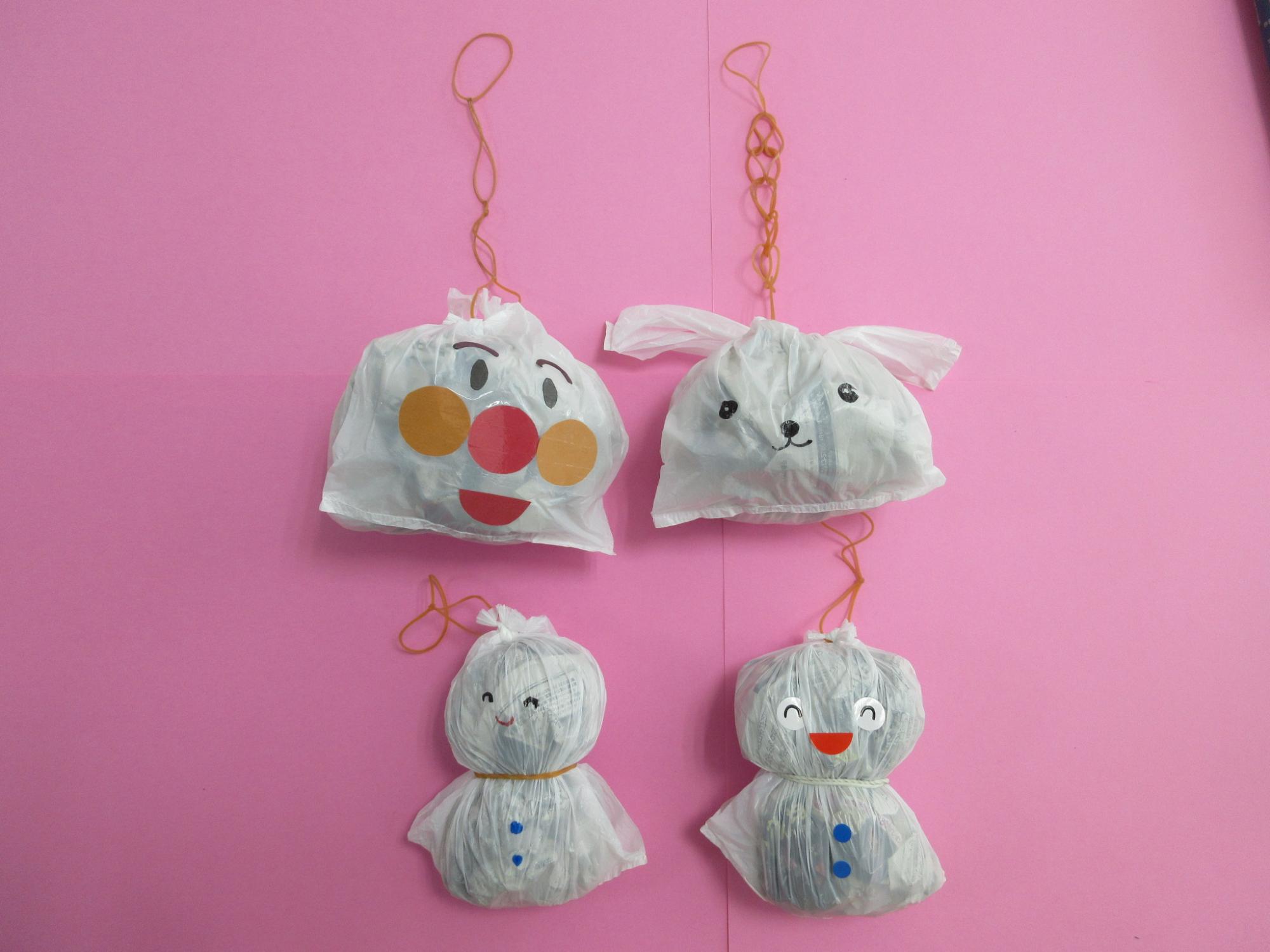 輪ゴムを取り付けられたレジ袋に動物の顔やキャラクターの顔が描かれている写真