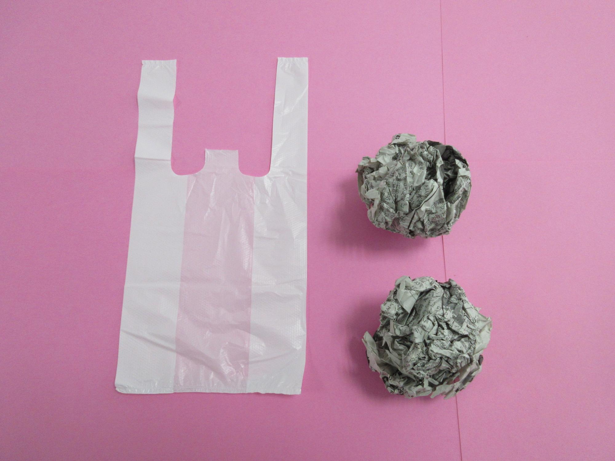 レジ袋と丸められた新聞紙2つが並べられている写真