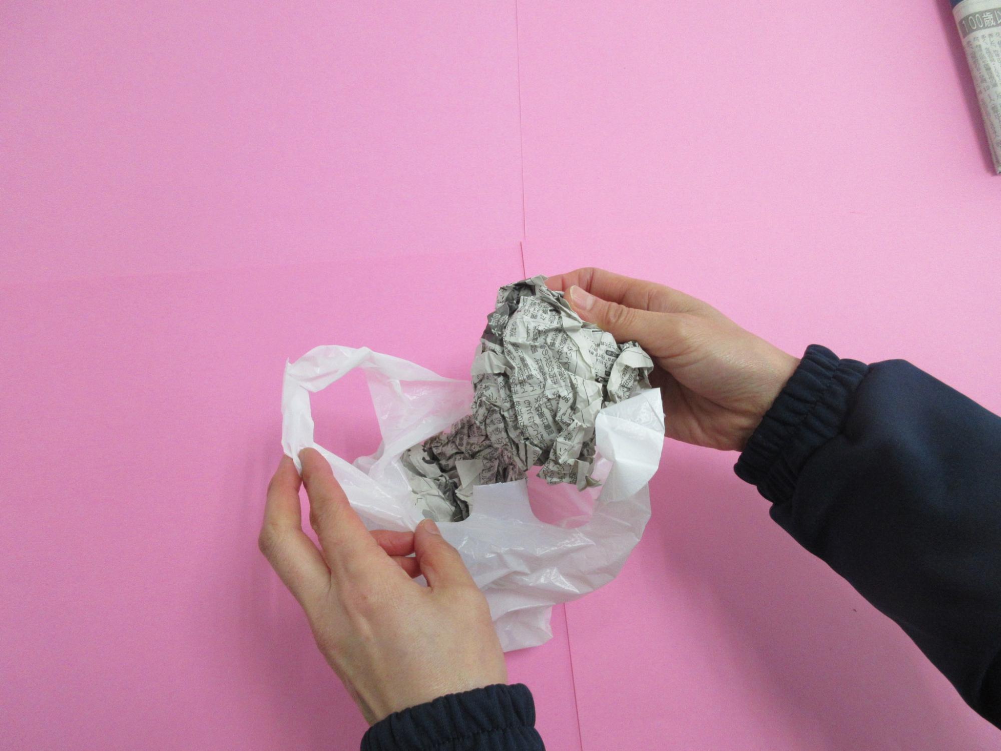 丸めた新聞紙をレジ袋に入れている写真