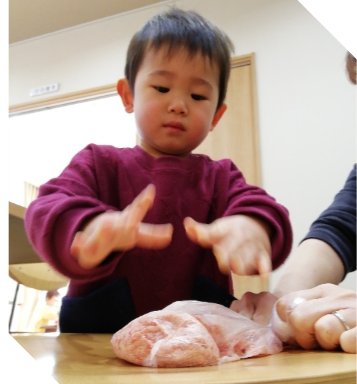 子どもがハンバーグのタネをこねる様子