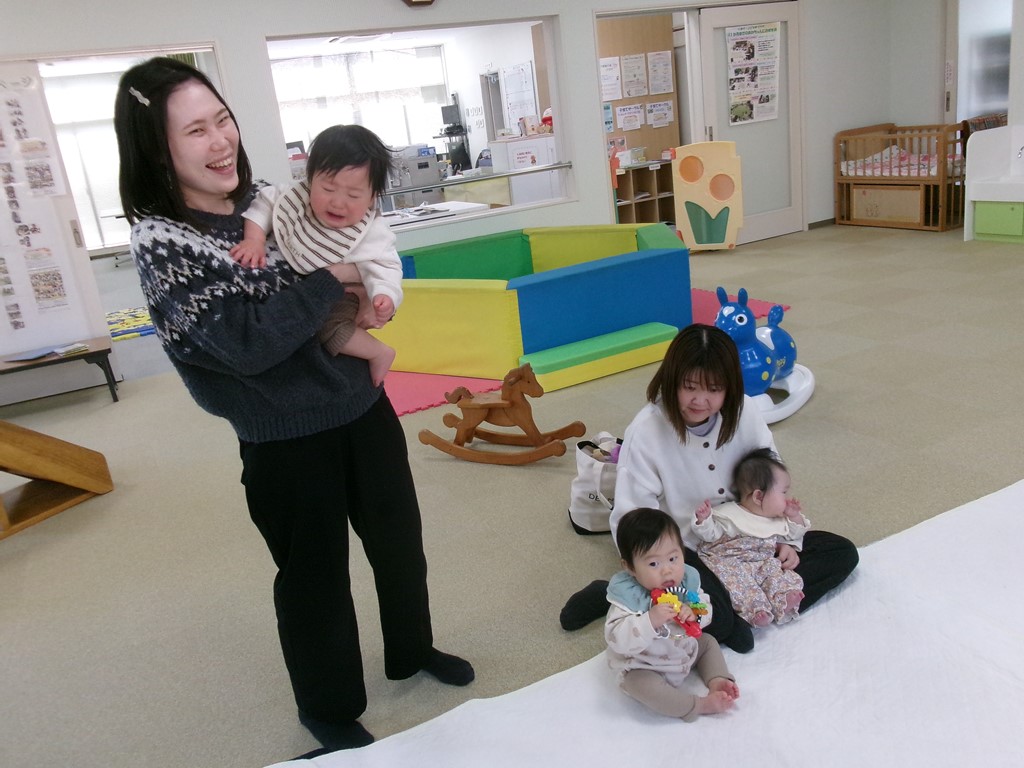 泣いている赤ちゃんを抱っこする母の様子