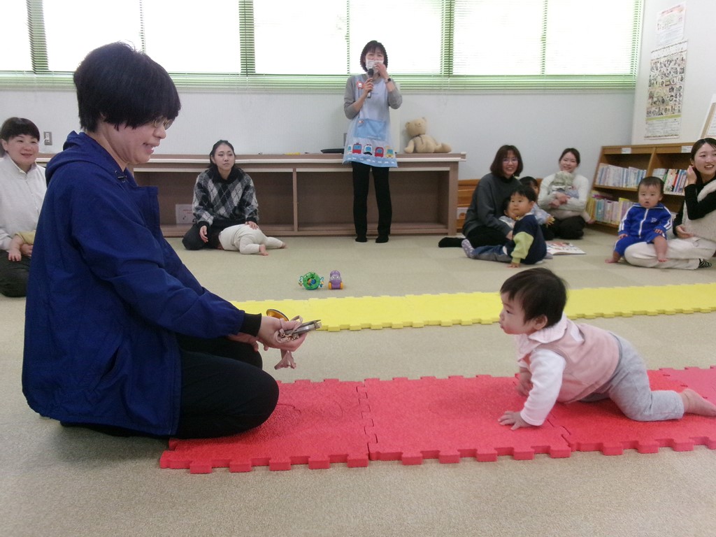 ハイハイする赤ちゃんを待ち構える母の写真