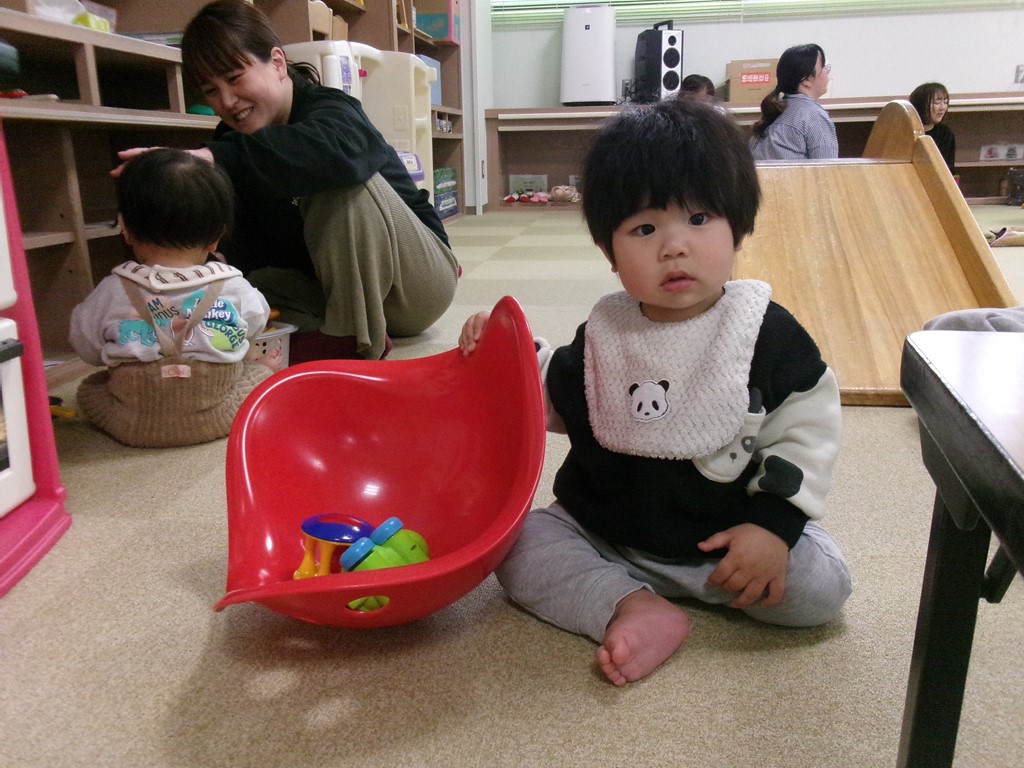 おもちゃんで遊んでいるあかちゃんの写真