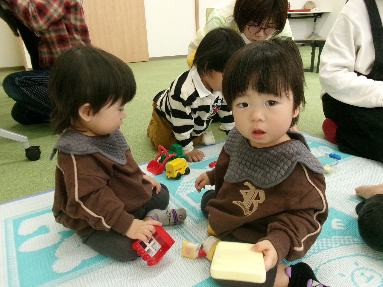 双子がおもちゃで遊ぶ様子。