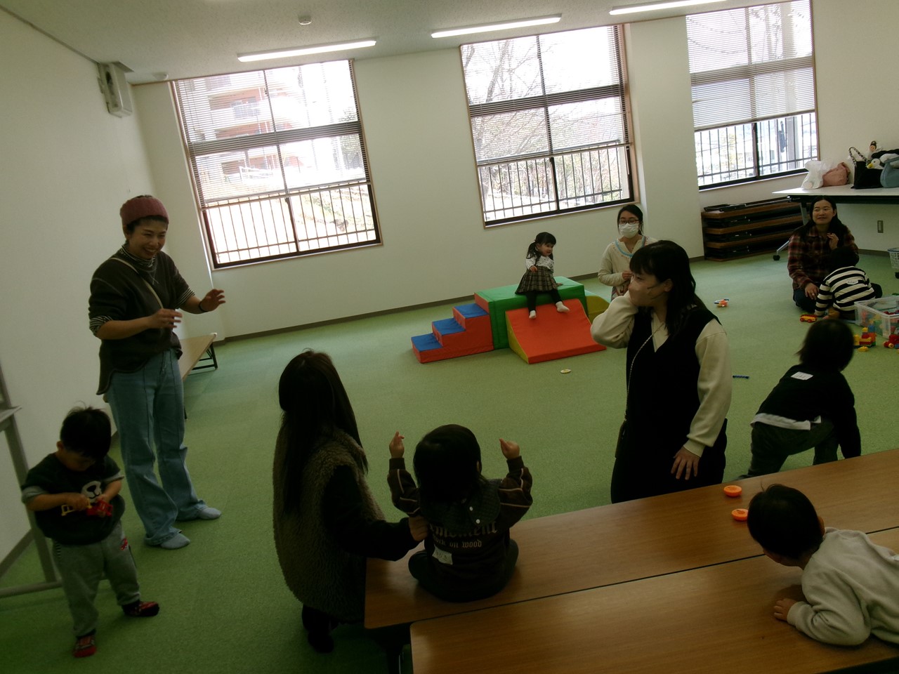 双子を育てる保護者同士で楽しくおしゃべりをする様子。