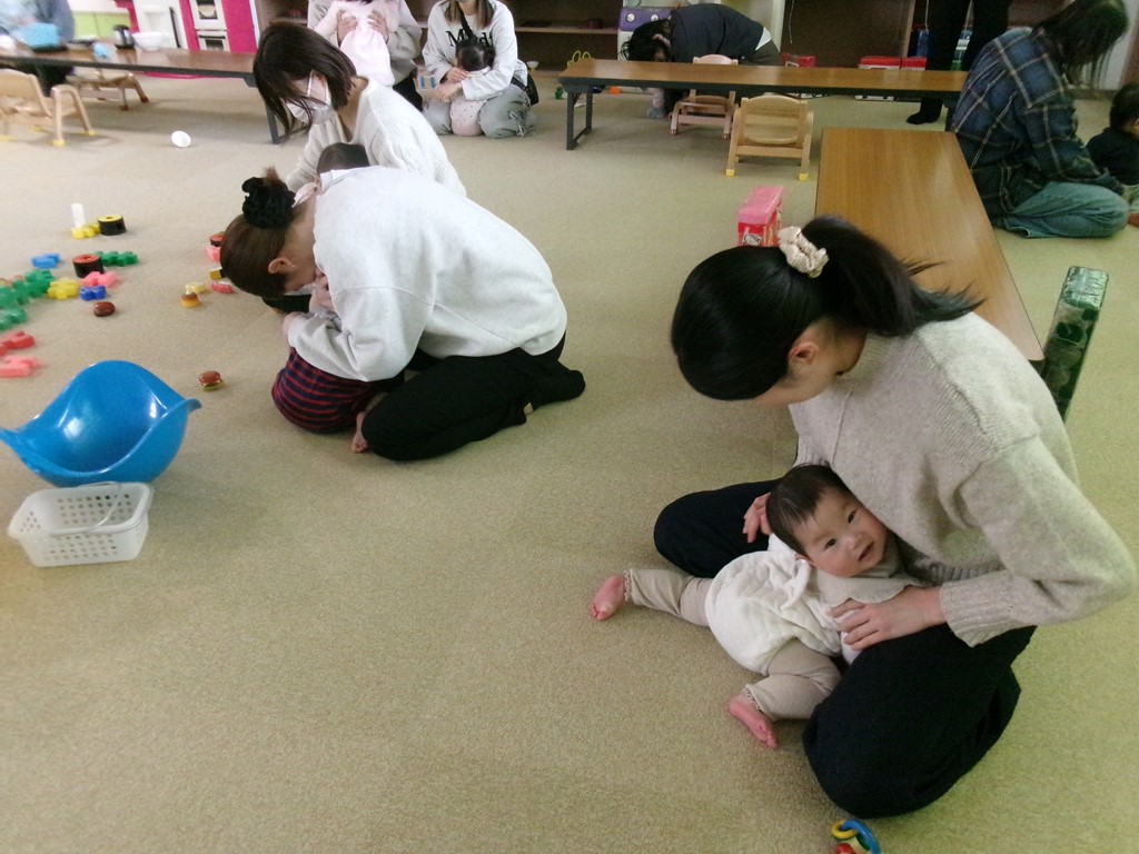 親子が座り、頭を守るように小さくなっている写真