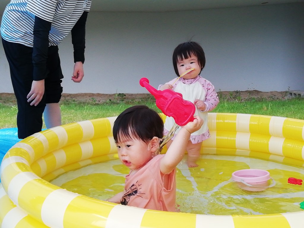 子ども用プールで遊ぶ幼児