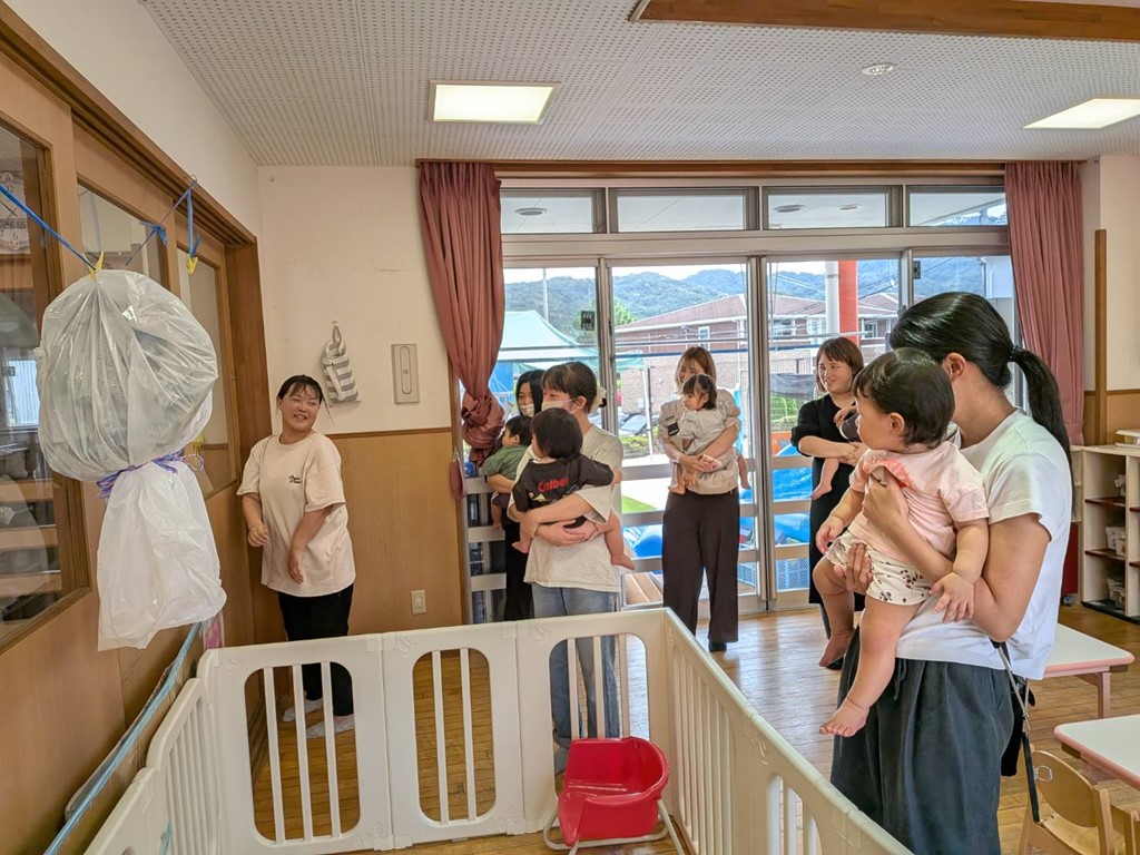 子どもを抱っこして、園を見学する親子の様子