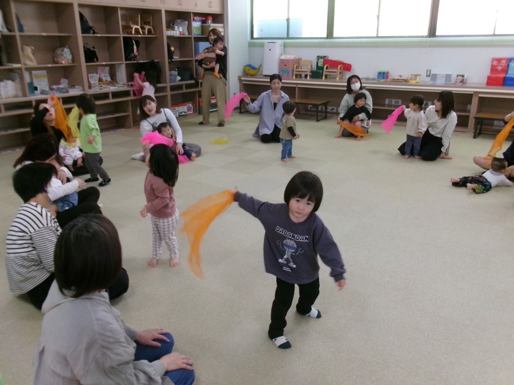 スカーフを持った子どもたちが体を動かしている写真