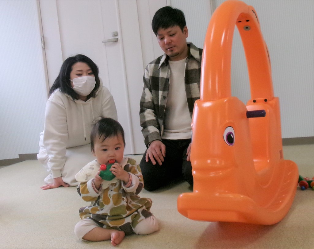 子どもの遊ぶ姿を見つめるお父さんとお母さん