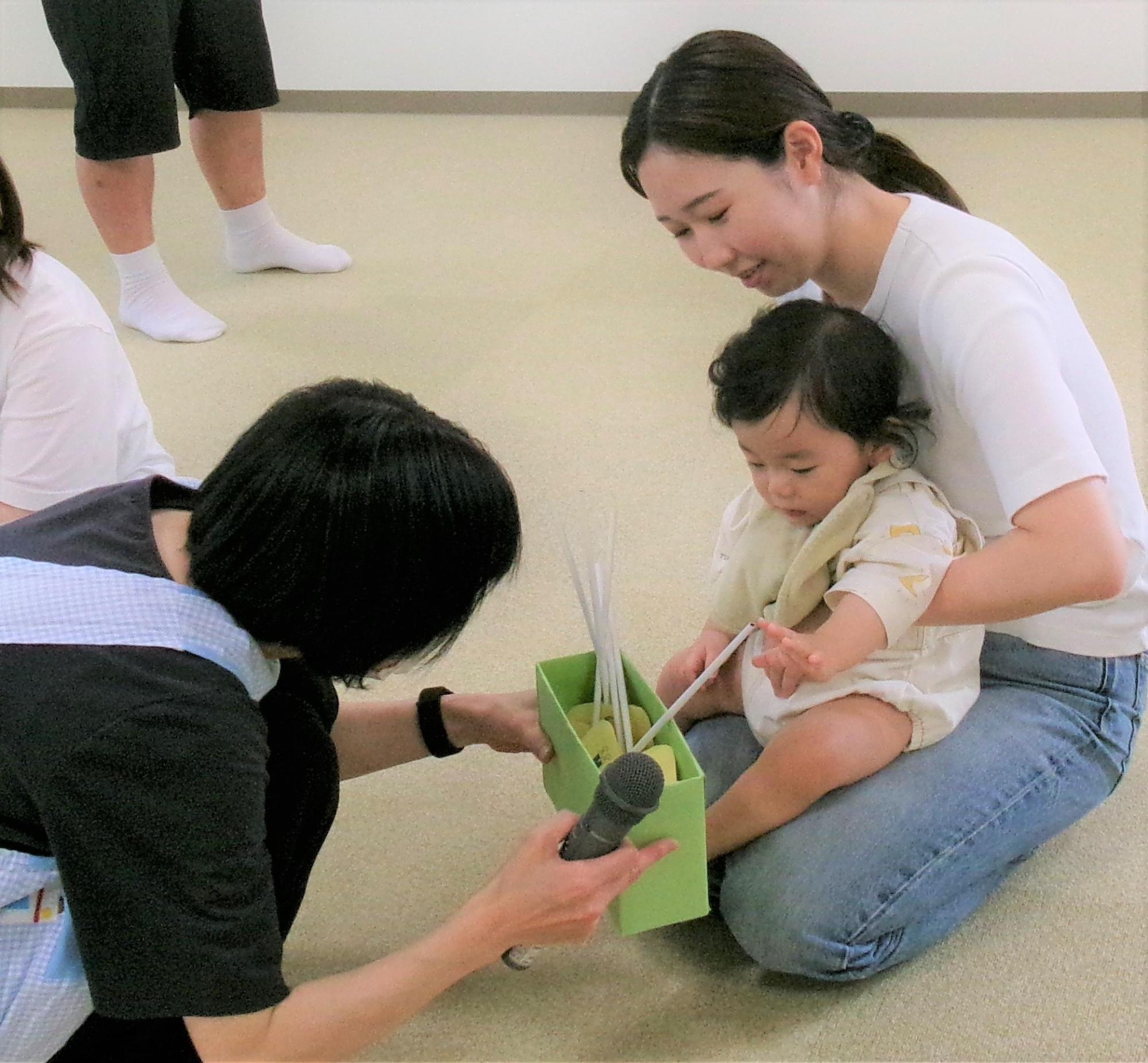 7月の誕生日会でくじ引きをする親子の様子