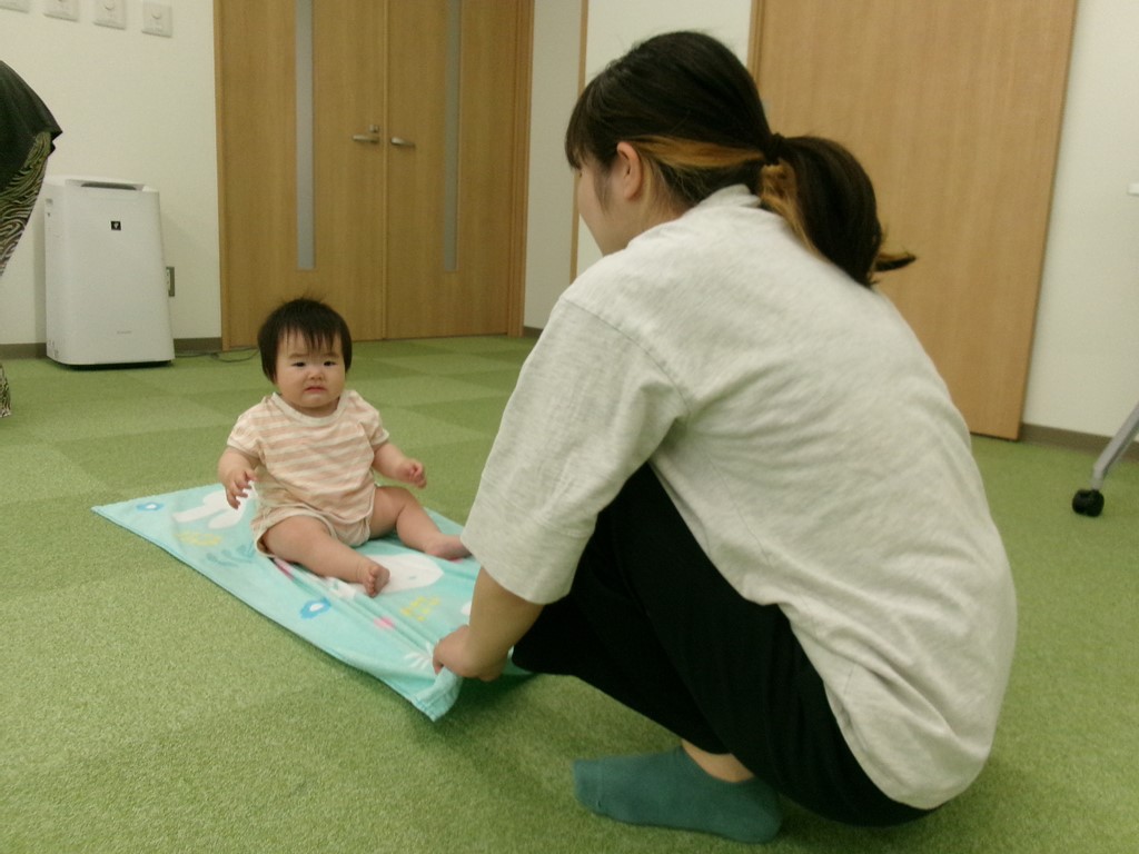 6月アタッチメントジムでタオルを使った体操をする子どもと母の様子