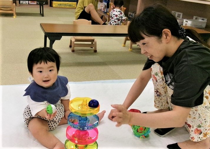 多目的室のおもちゃで一緒に遊ぶ親子の様子
