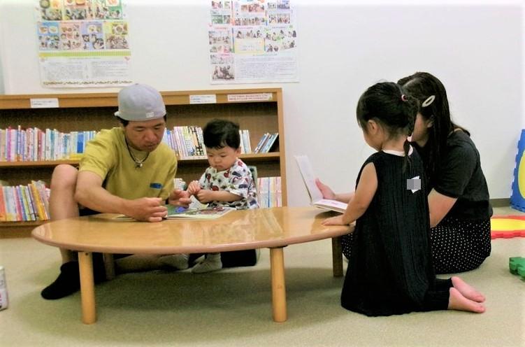 子どもに絵本の読み聞かせをしている2組の親子の様子