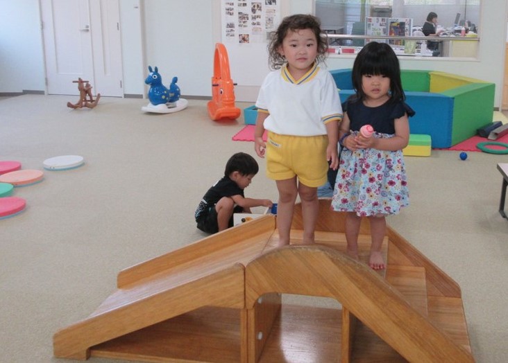 子ども用滑り台の上に立っている女の子2人