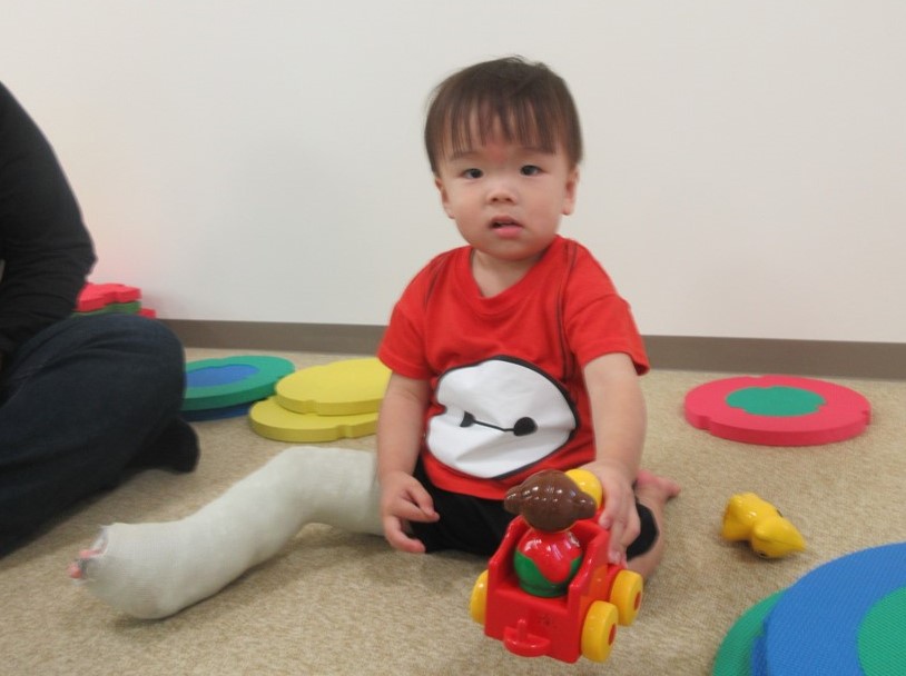 車のおもちゃを見せる男の子