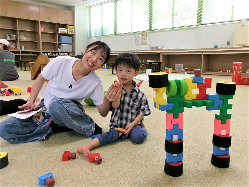 多目的室でおもちゃで一緒に遊ぶ親子