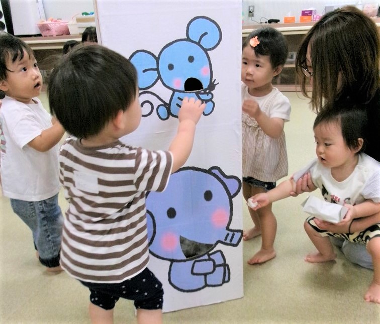 子ども達がお月見のお団子を動物たちに食べさせている様子