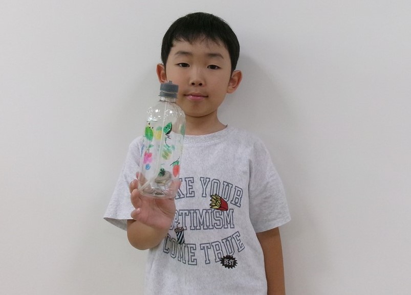 7月のうたとおはなしの広場で作った工作を見せる子ども