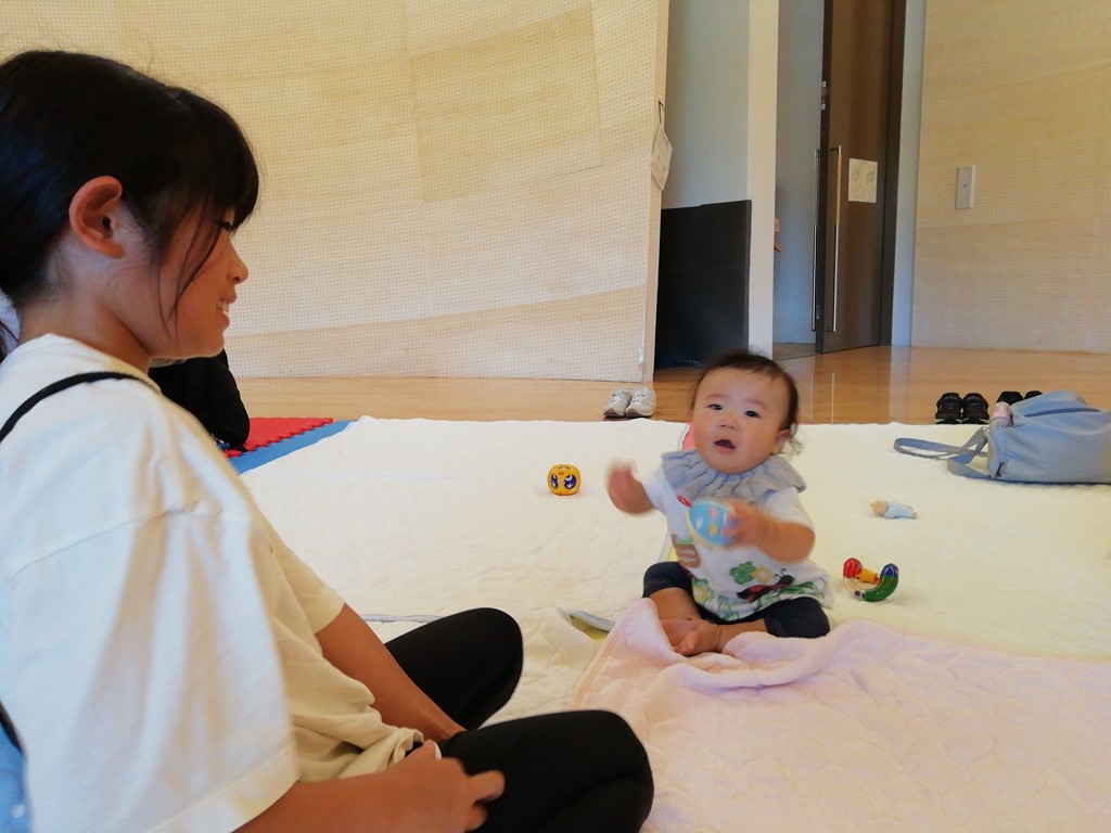 出張おひさまルームのおもちゃで遊ぶ赤ちゃんをみる母