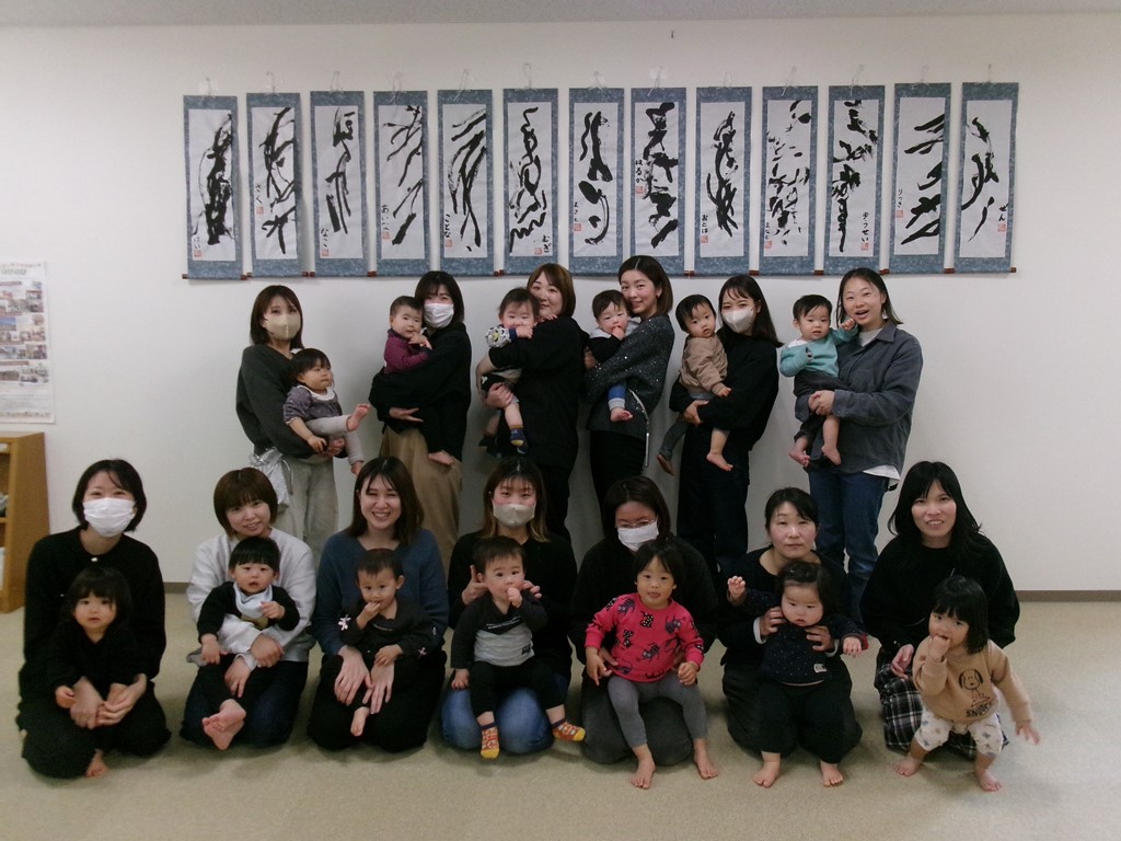 壁に掛けた作品と参加者の集合写真
