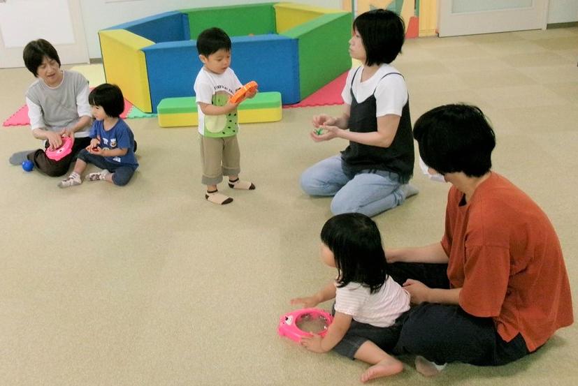 7月わくわくキッズで楽器を演奏する子どもを見守る母の様子