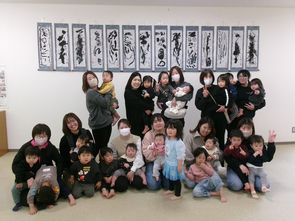 完成した作品の前で集合写真を撮っている写真