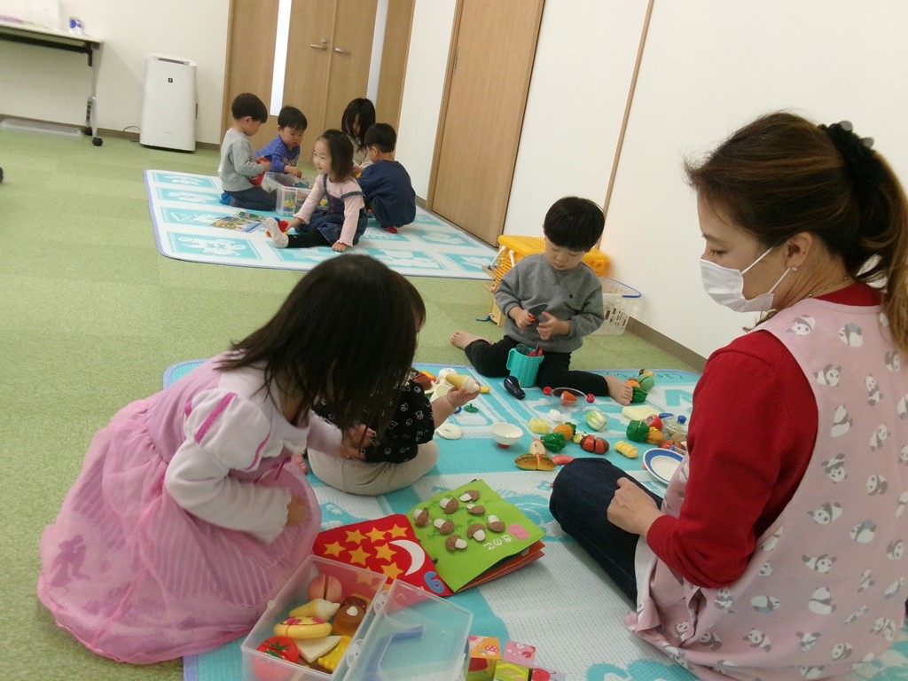 ベビーマッサージ中に上の子を同室で託児をする様子