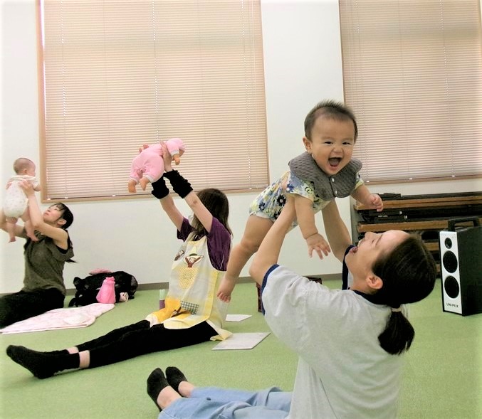 ふれあい遊びで母にたかいたかいーをしてもらい笑顔になる子ども