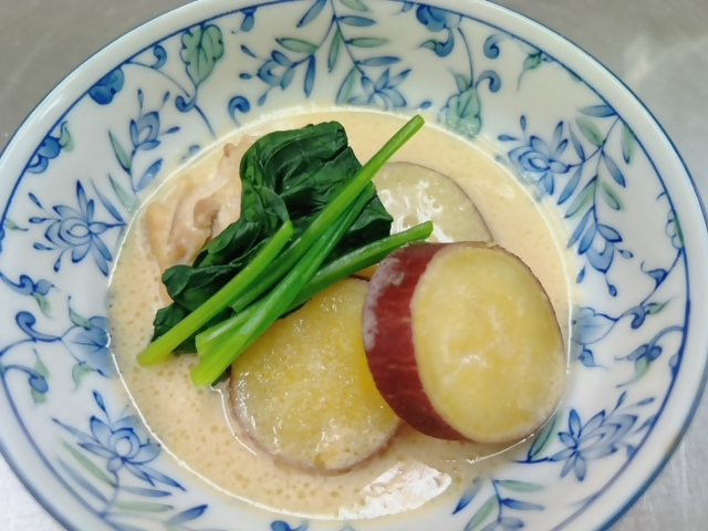 ほうれん草とさつまいもの煮物が盛られた皿の写真