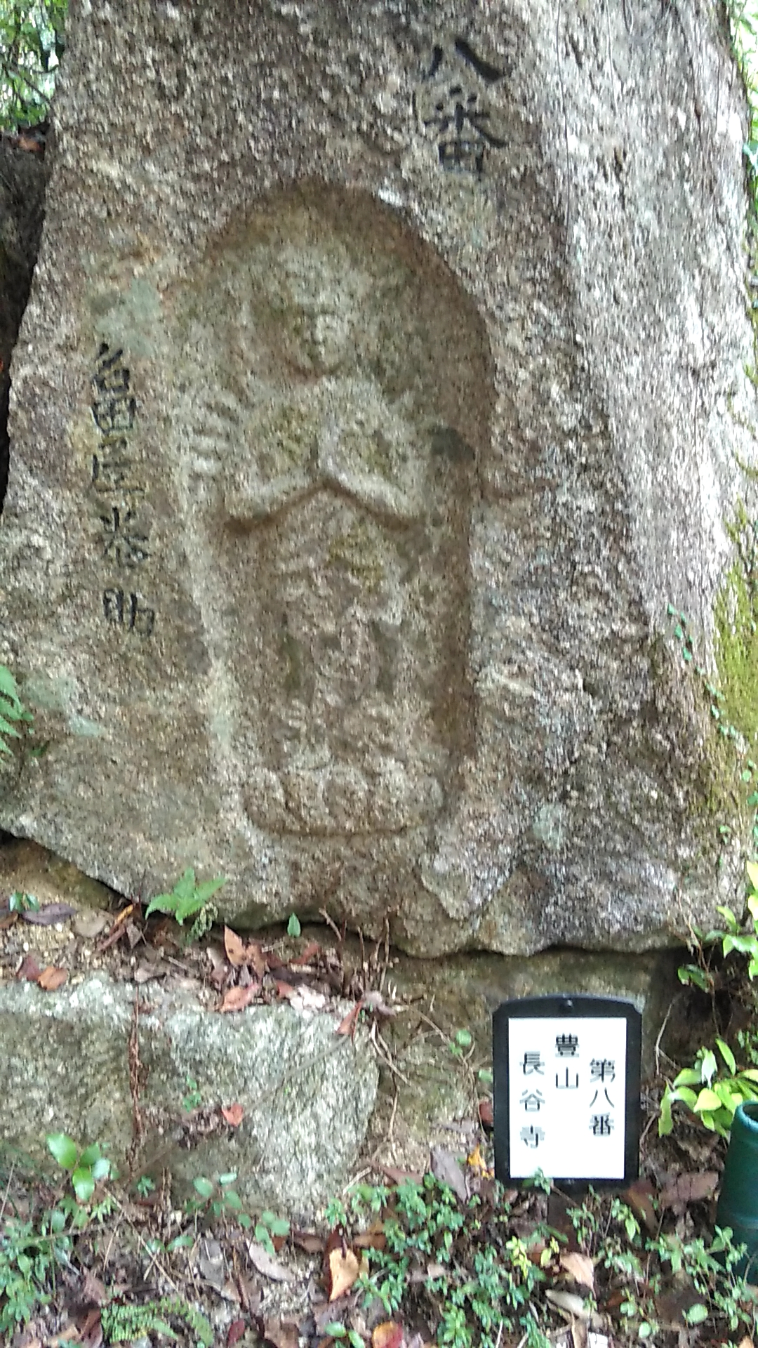 手を合わせ蓮の葉に立っている様子が彫り込まれた八番の摩崖仏の写真