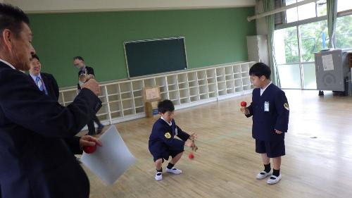 小学生が中遊びでけん玉をする様子
