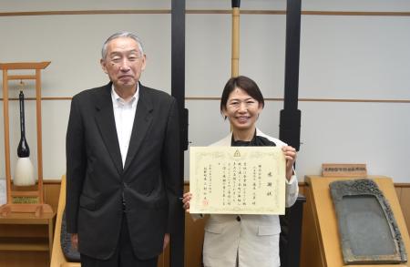 感謝状を持って記念撮影に臨む藤本代表取締役と熊野町長の写真