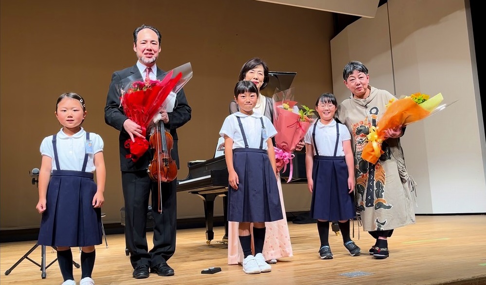 子どもたちといっしょに記念撮影に臨む三又治彦さん遠藤さつきさんの写真