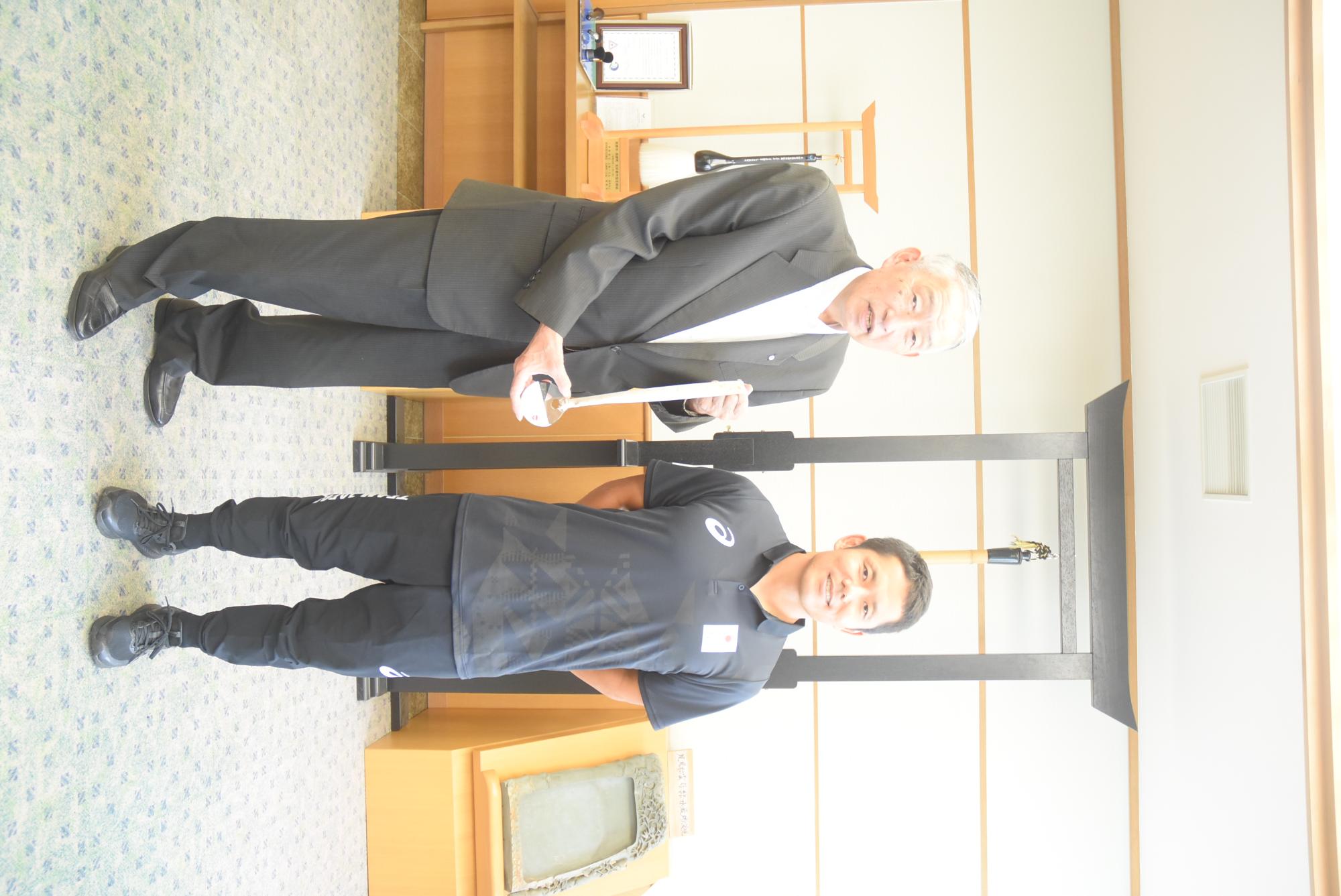 熊野町庁舎の熊野町町長と記念撮影に臨む後藤将起選手の写真